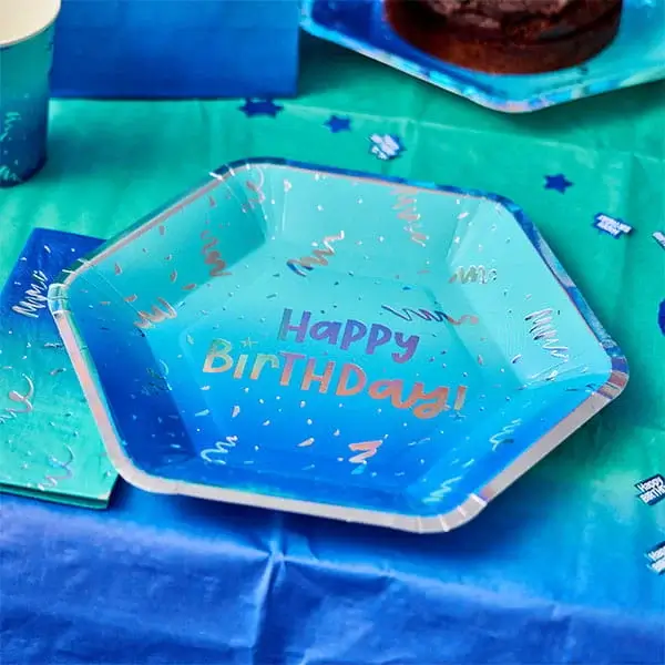 Blue Happy Birthday party plate on a matching table setting with confetti and themed decorations.
